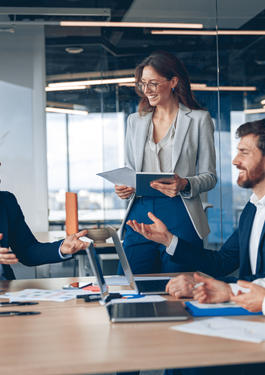Eine Gruppe von Personen sitzt an einem Schreibtisch, auf dem Dokumente liegen.