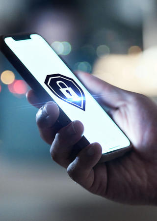 Person hält Handy in der Hand, auf dem ein großes Sicherheitsschloss zu sehen ist